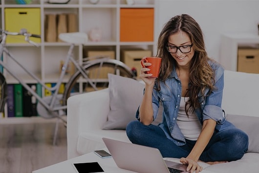 women on sofa with laptop