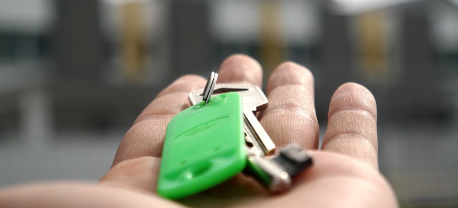 Hand holding new house keys