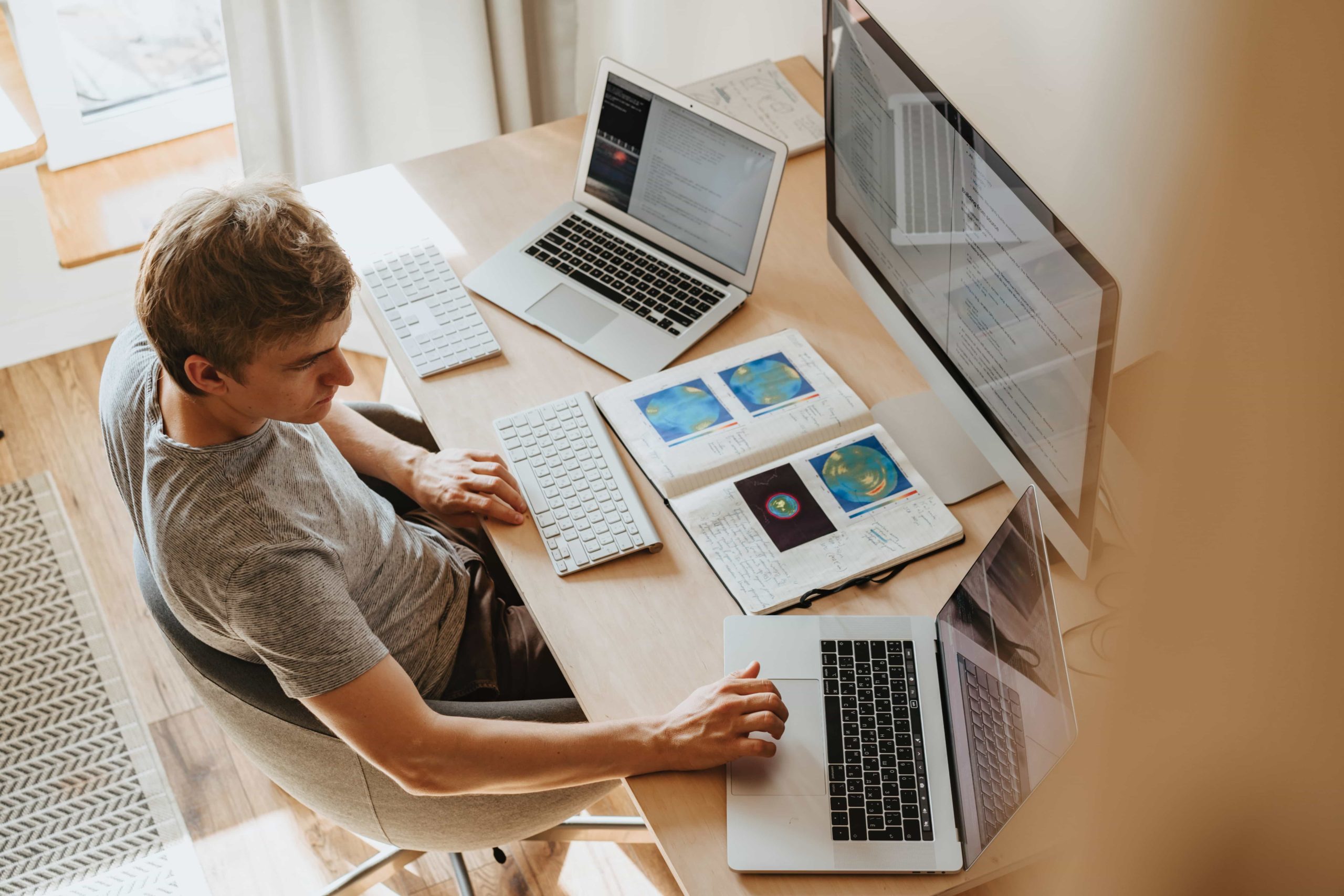 A person working on multiple computers in home office