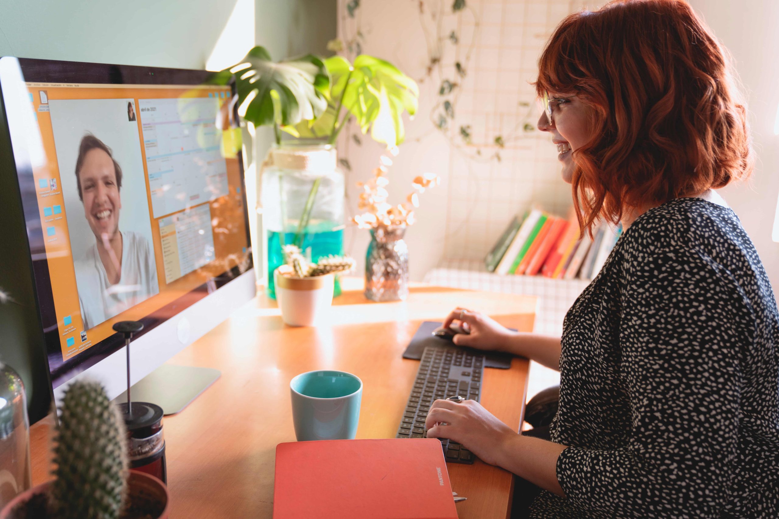 A person working on a computer during a video call at their home office